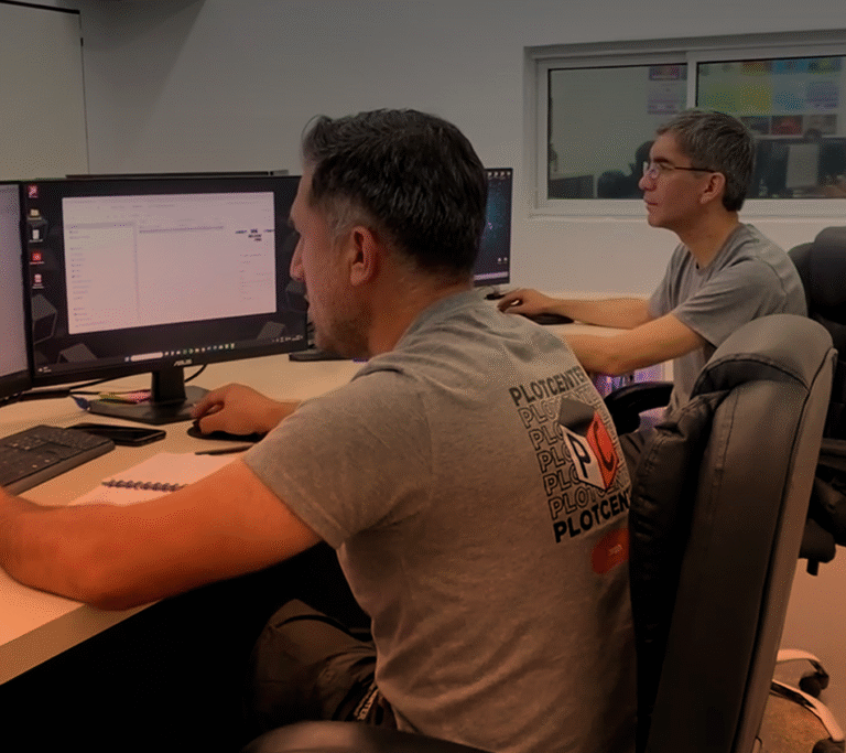 Dos integrantes del equipo técnico trabajando frente a sus computadoras