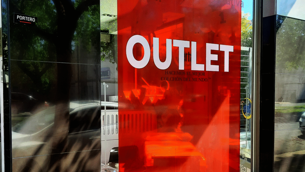 Vinilo rojo impreso con la palabra OUTLET aplicado sobre una vidriera
